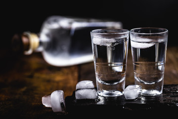 Cold cocktail with tonic, vodka and ice on the wooden background. World Vodka or Brandy Day