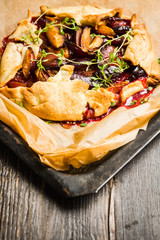 Freshly baked tart with plums and thyme on the rustic background. Selective focus. Shallow depth of field.