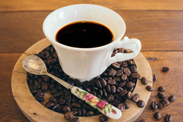 Black coffee in a white cup on a wooden table in cafe