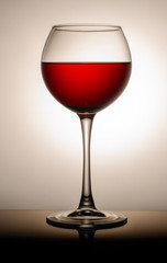 Wine glass with a drink on a colored light background