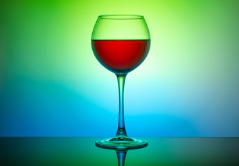 Wine glass with a drink on a colored light background