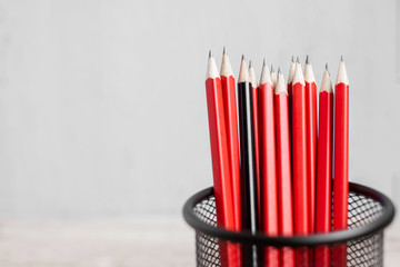 Black pencil different from crowd of red pencils. Unique Leader, strategy, independence, think different, business and success concept