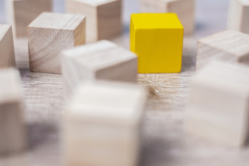 Yellow cube block different from crowd of wood blocks. Unique Leader, strategy, independence, think...