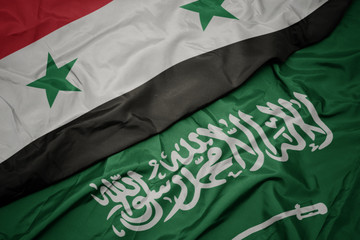 waving colorful flag of saudi arabia and national flag of syria.