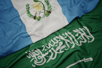 waving colorful flag of saudi arabia and national flag of guatemala.