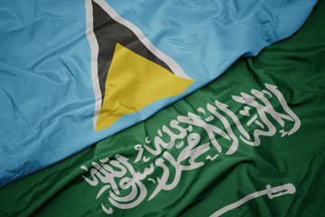 waving colorful flag of saudi arabia and national flag of saint lucia.