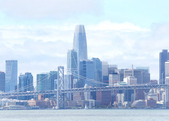 Fototapeta premium San Francisco city on a windy cloudy day with bay bridge foreground. As part of Interstate 80, the bridge connects San Francisco and Oakland, and carries about 260,000 vehicles a day.