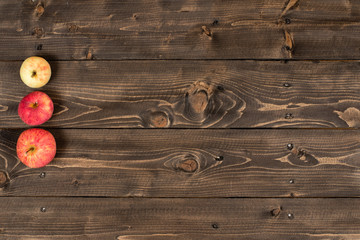 Three apples on a wooden rustic table top view