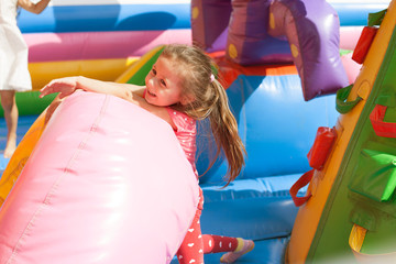 Fototapeta na wymiar A cheerful child plays in an inflatable castle