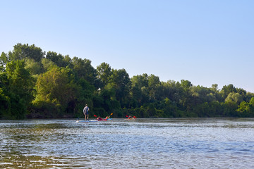 Fototapeta na wymiar People in kayak and SUP paddling in Danube river at spring. Concept of active vacation