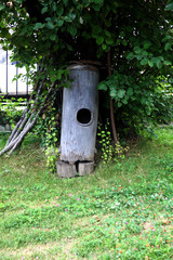 Old wooden butter churn on the green grass