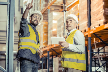 Joyful young man listening to his colleague