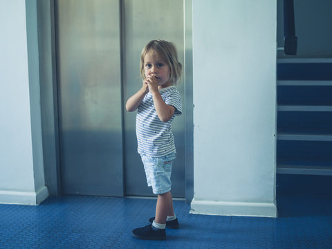Little toddler standing by lift