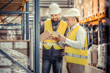 Joyful bearded male person checking information on box