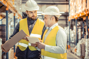 Serious manager checking his product on factory