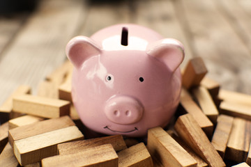Pink piggy bank on wood,risk of collecting money concept.