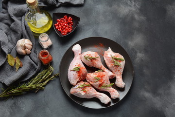 Raw uncooked chicken legs for barbecue grill with salt, herbs, garlic and olive oil. Meat with ingredients for cooking