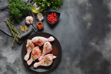 Raw uncooked chicken legs for barbecue grill with salt, herbs, garlic and olive oil. Meat with ingredients for cooking
