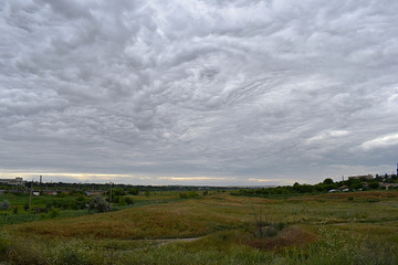 Landscape with sky covered by bizarre clouds.