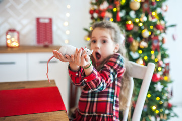 A beautiful girl in fear holds a white mouse, a rat. The symbol of the new year.