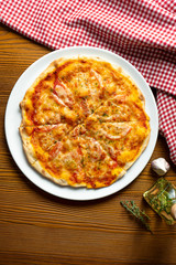Fresh homemade Margarita pizza on a wooden background in composition with a red cloth and olive oil. Italian Cuisine. Top view food photo