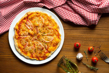 Fresh homemade Margarita pizza on a wooden background in composition with a red cloth and olive oil. Italian Cuisine. Top view food photo