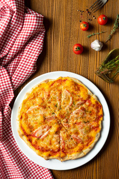 Fresh homemade Margarita pizza on a wooden background in composition with a red cloth and olive oil. Italian Cuisine. Top view food photo