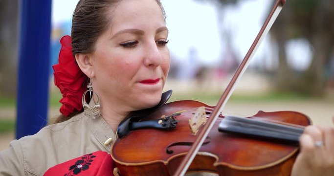 Hispanic Mexican mariachi latino woman musician plays violin music at cultural festival in Los Angeles, California, 4K