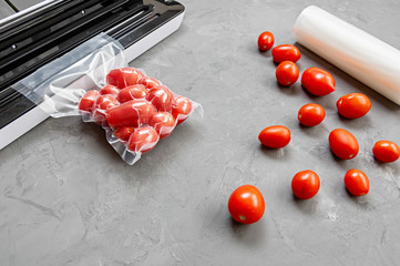 Plastic sealing machine. Vacuum packaging of fresh tomatoes. Flat lay.