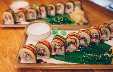 Close-up Set Philly california avocado eel smoked Red Green dragon California ,Ebi Roll philadelphia rolls assorti ginger seaweed in night dining restaurant. Delicious Sushi rolls served in a bar.