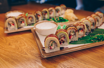 Close-up Set Philly california avocado eel smoked Red Green dragon California ,Ebi Roll philadelphia rolls assorti ginger seaweed in night dining restaurant. Delicious Sushi rolls served in a bar.