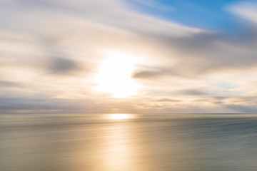 Obraz premium Long exposure of the sun and clouds over the sea in England, UK.