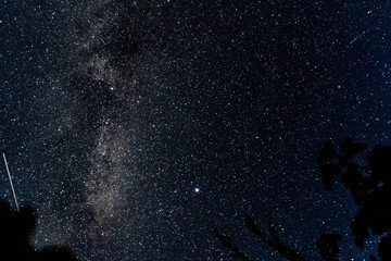 Overhead milky way with stars in clear summer night. Old barn house. Country side.