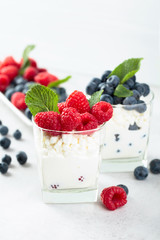 Cottage cheese with cream, raspberry and blueberry garnished with fresh mint.