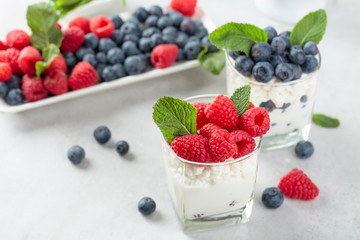 Cottage cheese with cream, raspberry and blueberry garnished with fresh mint.