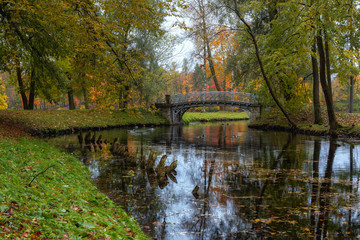 Obraz premium Gatchina, Russian Federation - October 10, 2018: Bright autumn in the Gatchina Museum-Reserve, view of the pond and bridge in the palace and park ensemble in Gatchina.