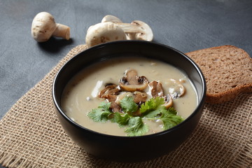 A bowl of Mushroom Cream Soup with fried champignons and fresh parsley. Winter, autumn hot soup concept 