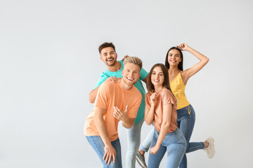 Group of young people in stylish casual clothes on light background