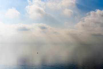 Obraz premium White cloudy sky over the pastel blue sea.