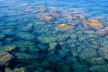 Blue sea on the rocks at sunset.
