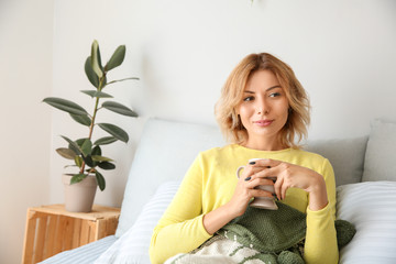 Portrait of beautiful woman drinking coffee in bedroom