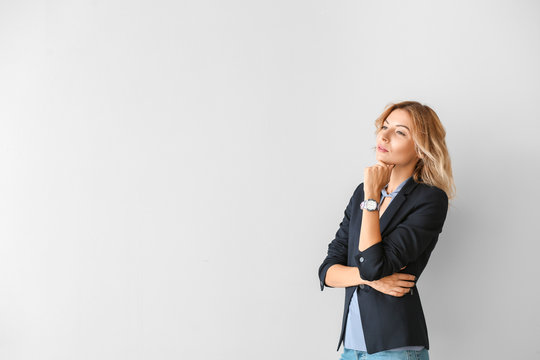 Portrait of beautiful thoughtful businesswoman on light background