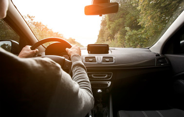 The young man driving the modern car on asphalt road