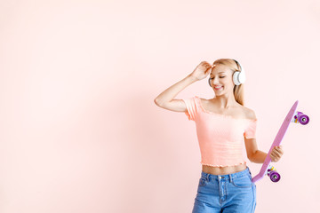 Beautiful young woman with skateboard listening to music on color background