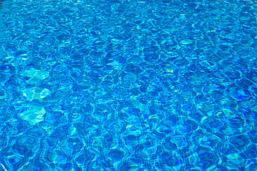 Transparent clear water in the pool. blue mosaic tiles, water texture. Blue water pool bottom background.