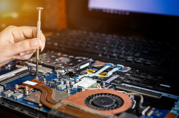 Technician repairing broken laptop notebook computer