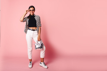 Fashion Model girl full length portrait isolated on pink background. Beauty stylish brunette woman posing in fashionable clothes in studio. Casual style, beauty accessories. High fashion urban style