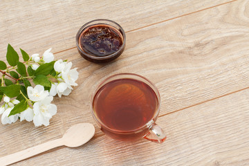 Glass cup of green tea with white jasmine flowers
