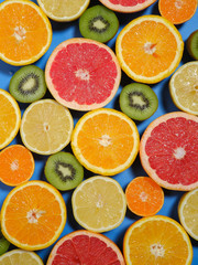 Fresh summer fruits background. Healthy food concept. Flat lay. Tropical summer mix grapefruit, orange, mandarin, kiwi, lemon