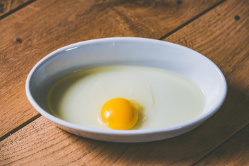 Jaune d'oeuf dans un plat blanc pour cuisiner	